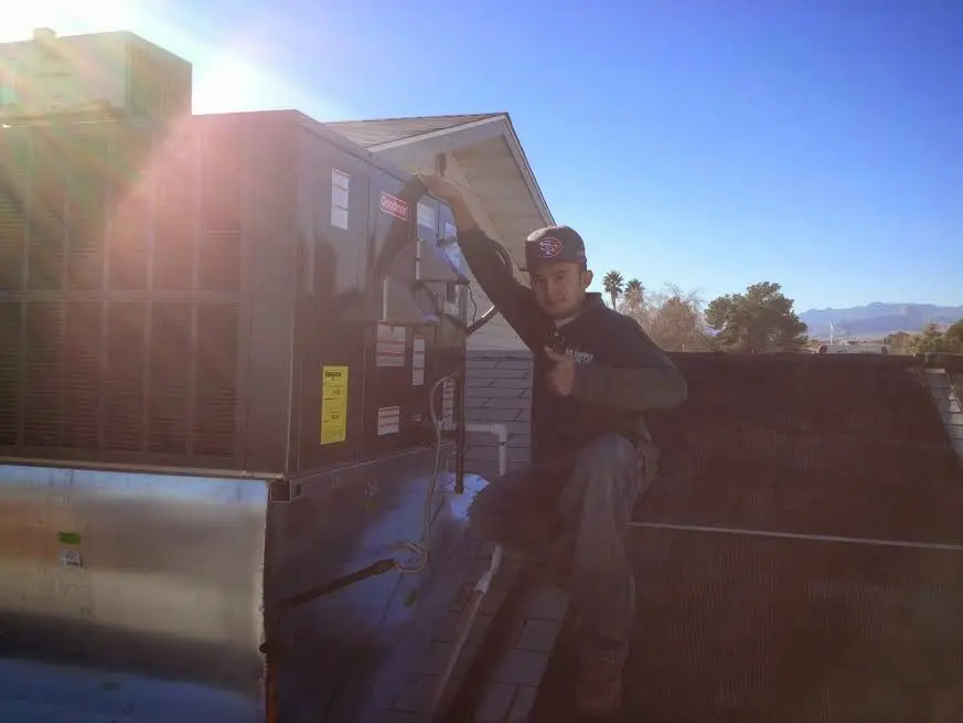 HVAC technician performing Boiler Repair on a rooftop unit in Harwich